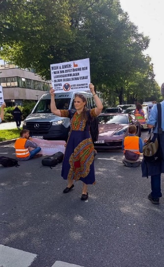 Eine Frau steht auf der Straße und hält ein Schild hoch.